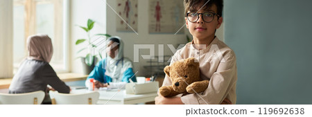 Young Boy Holding Teddy Bear in Medical Office Young Boy Holding Teddy Bear in Medical Office 119692638