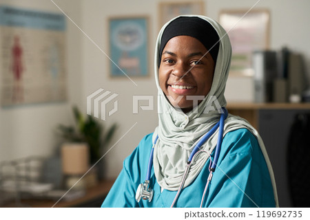 Smiling Muslim Female Doctor Wearing Medical Attire in Clinic Smiling Muslim Female Doctor Wearing Medical Attire in Clinic 119692735