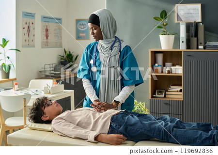 Muslim Medical Professional with Child in Examination Room Muslim Medical Professional with Child in Examination Room 119692836
