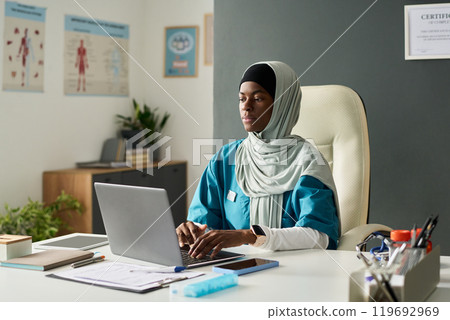 Working Professional Using Laptop at Office Desk 119692969