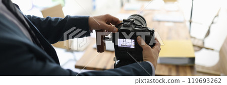 Successful businessman in suit sets up professional camera 119693262