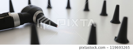 Otoscope for ear examination surrounded by black funnels Otoscope for ear examination surrounded by black funnels 119693265