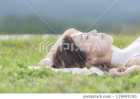 A young woman lying on the grass A young woman lying on the grass 119693280