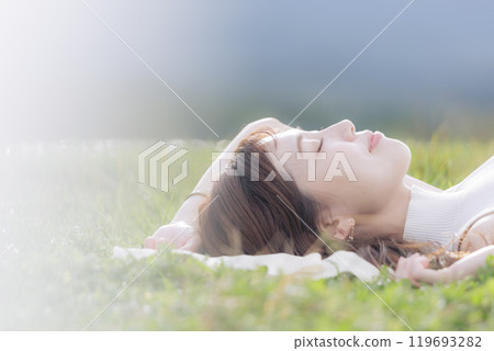 A young woman lying on the grass 119693282