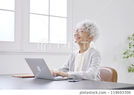 Senior businesswoman imagining in front of laptop computer, office Senior businesswoman imagining in front of laptop computer, office 119693306