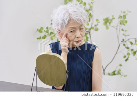 Elderly woman suffering from wrinkles around the eyes 119693323