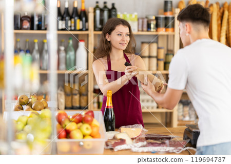 Young woman seller offers wine to man 119694787