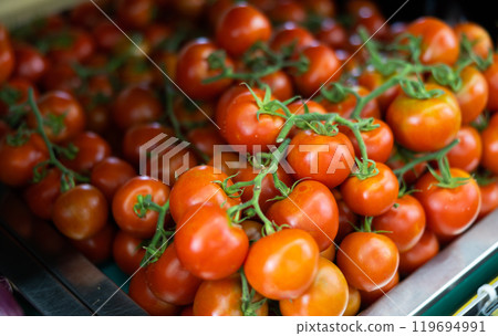 Pile of tomatoes lie on counter in shop 119694991