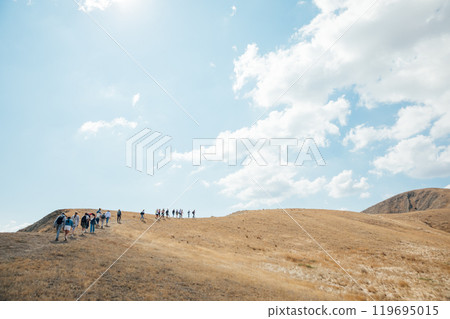 Tourists travelers climb to the top of the mountain on a hike 119695015