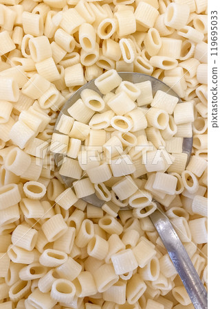 Close-Up of Cooked Turkish Ditalini Pasta with Perforated Serving Spoon in Kitchen Setting.A detailed, close-up shot of cooked ditalini pasta, commonly used in Turkish cuisine Close-Up of Cooked Turkish Ditalini Pasta with Perforated Serving Spoon in Kitchen Setting.A detailed, close-up shot of cooked ditalini pasta, commonly used in Turkish cuisine 119695033
