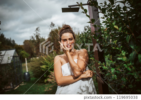 Beautiful woman resting in garden after using home sauna. Woman taking care of her body and mind, wellness routine. Beautiful woman resting in garden after using home sauna. Woman taking care of her body and mind, wellness routine. 119695038