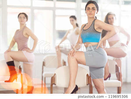 Dark-haired girl performing sass dance with chair at group class 119695306