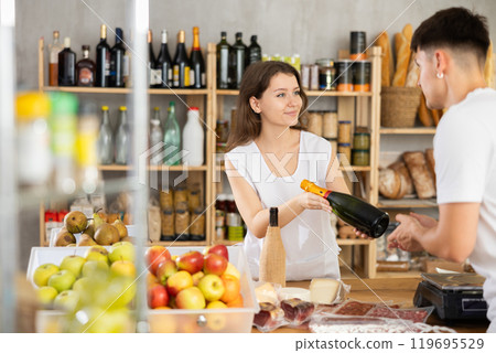 Young woman seller offers wine to man 119695529