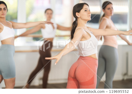 Teenage girl participating in beginner group ballet class Teenage girl participating in beginner group ballet class 119695552