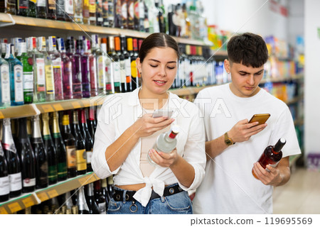 Married couple scans QR code from label on alcoholic drink 119695569