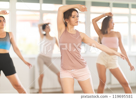 Young female dancer practicing jazz-funk at group class 119695581