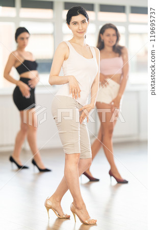 Young woman performing sass dance during group class 119695737