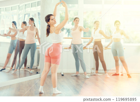 Young ballerinas rehearse ballet poses during ballet classes 119695895