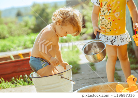 A little boy is bathing in a basin 119697336