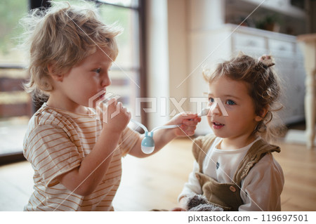 Boy using nasal suction bulb to clear mucus from sisters nose. Boy using nasal suction bulb to clear mucus from sisters nose. 119697501