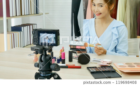 Beauty blogger video production for female fashion blog online cosmetic adviser record woman lifestyle tutorial. Trendy female vlogger showing how to use cosmetics products live via social media. 119698408