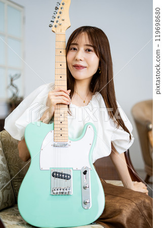 Long-haired woman with an electric guitar 119698680