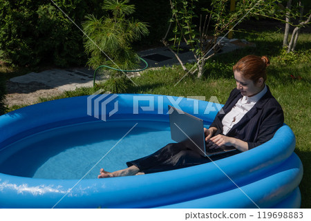 Caucasian business woman working on laptop while sitting in swimming pool. Caucasian business woman working on laptop while sitting in swimming pool. 119698883