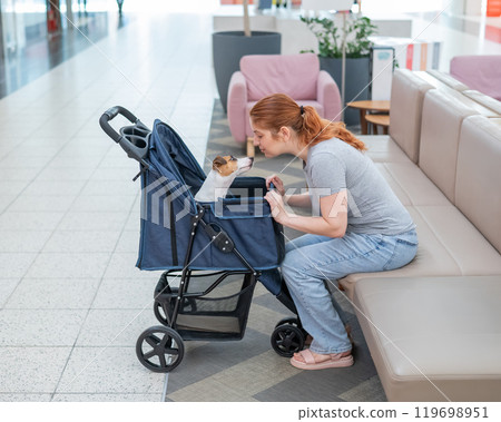 Caucasian woman petting her Jack Russell terrier dog. Shopping with a pet in the mall. Caucasian woman petting her Jack Russell terrier dog. Shopping with a pet in the mall. 119698951