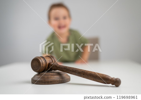 Little boy behind judge's gavel. Little boy behind judge's gavel. 119698961
