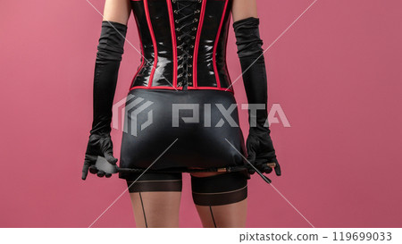 Beauty lady in a black latex dress holding the whip 119699033