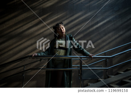 Portrait of a young Asian woman posing in the subway near the stairs.  119699158