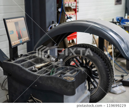 Wheel being balanced in a car workshop. Wheel being balanced in a car workshop. 119699229