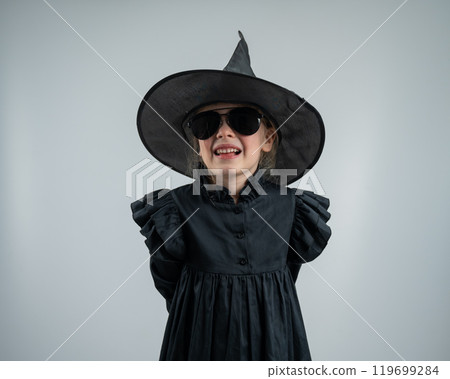 Portrait of a little Caucasian girl in a witch costume on a white background.  119699284