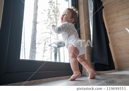 Baby boy standing by the patio window.  Baby boy standing by the patio window.  119699351