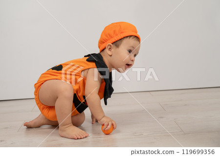 Cute Caucasian boy in pumpkin costume for Halloween.  119699356