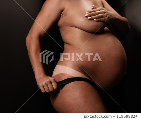Pregnant woman pulls back her panties showing instant tan. Vertical photo.  119699824