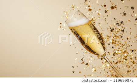 Champagne glass with golden confetti flying, representing Christmas and New Year celebration. Perfect for festive backgrounds. 119699872