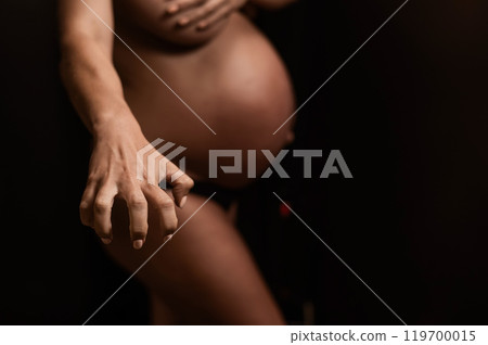 The master applies bronzer with a spray on the hands of a pregnant woman. Instant tan. The master applies bronzer with a spray on the hands of a pregnant woman. Instant tan. 119700015