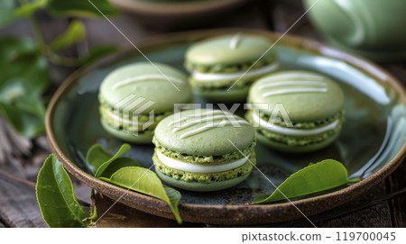 Matcha Green Tea Macarons: Delicate macarons with white chocolate ganache, arranged on a Japanese ceramic plate with green tea leaves Matcha Green Tea Macarons: Delicate macarons with white chocolate ganache, arranged on a Japanese ceramic plate with green tea leaves 119700045