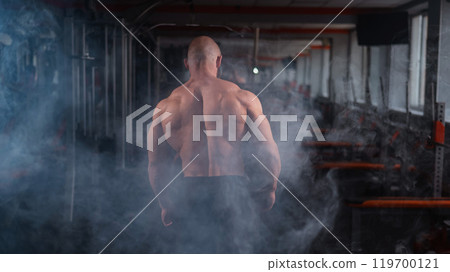 Caucasian bald man posing in the gym. 119700121