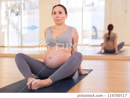 Pregnant woman is engaged in yoga. Butterfly Pose or Baddha Konasana Pregnant woman is engaged in yoga. Butterfly Pose or Baddha Konasana 119700517