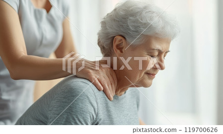 Senior woman enjoying a neck massage in a spa, feeling relaxed and rejuvenated. The therapist's healing touch eases stress and tension, promoting wellness 119700626