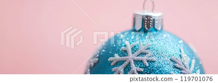 Glittery blue Christmas ornament with snowflake design on pink background, ideal for holiday mockups and designs. 119701076