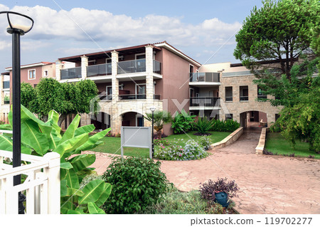 Modern buildings on the island of Crete, Greece. Hotel area and palm trees. Luxury tropical apartment resort complex. Modern buildings on the island of Crete, Greece. Hotel area and palm trees. Luxury tropical apartment resort complex. 119702277