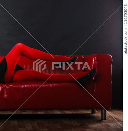 Fashion woman legs red pantyhose on couch 119703048