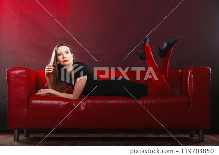 Fashion woman in red pantyhose on couch 119703050