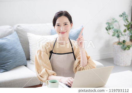 一位家庭主婦在電腦上做家庭會計和工作的圖像 看著相機時的要點和建議的指向姿勢。 一位家庭主婦在電腦上做家庭會計和工作的圖像 看著相機時的要點和建議的指向姿勢。 119703112