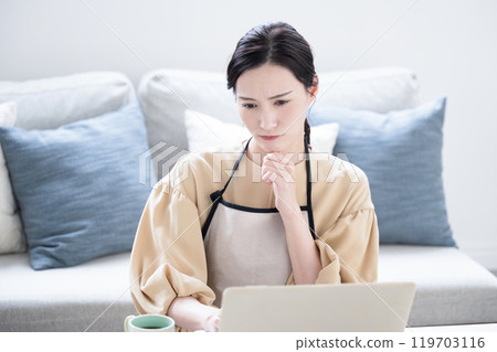 Negative image of a troubled housewife who is worried and thinking about keeping a household account book on a computer. Copy space available. Negative image of a troubled housewife who is worried and thinking about keeping a household account book on a computer. Copy space available. 119703116
