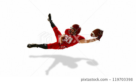 Focused man, American football player in red uniform in motion, catching the ball in mid-air, training isolated on white background Focused man, American football player in red uniform in motion, catching the ball in mid-air, training isolated on white background 119703398