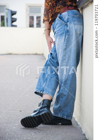 closeup of young woman wearing a large blue jeans  trousers in the street 119703721